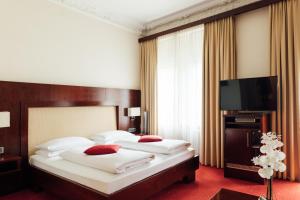威斯巴登Hotel de France Wiesbaden City的酒店客房设有两张床和一台平面电视。