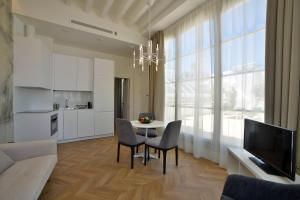 加的斯Plaza Mina Suites - Adults Recommended by Luxury Suites Cadiz的客厅配有桌椅和电视。