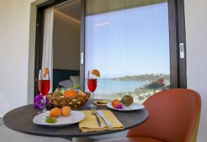 切法卢Sunset Hotel的一张桌子,上面放着一碗水果和酒杯