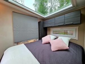 莱佩维尔塔曼斯卡哈约假日露营地的卧室配有带粉色和白色枕头的大床