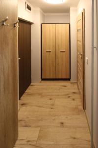 科沃布热格Apartament Navigare的走廊铺有木地板,设有两扇门
