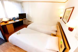 贝桑松西贝桑松尚图法瑞钟楼酒店的酒店客房配有两张床和一张书桌