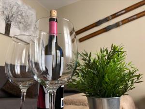普奇塞达Apartamento acogedor y familiar - WiFi+Chromecast的两杯酒杯旁的一瓶葡萄酒