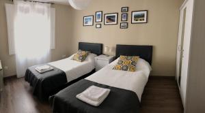 普奇塞达Apartamento acogedor y familiar - WiFi+Chromecast的客房设有两张床和窗户。
