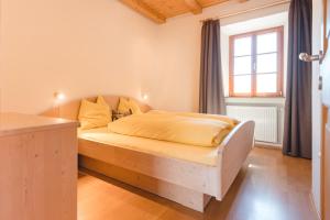 韦尔图尔诺Brugger Hof的一间卧室,卧室内配有一张木床