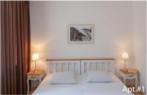 梅斯蒂亚svaneti apartment's的一间卧室设有两张床和两盏灯,墙上挂着一张照片