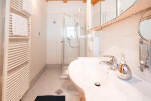 韦尔图尔诺Brugger Hof的白色的浴室设有水槽和淋浴。