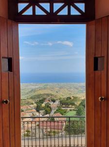 杰拉切Albergo Palazzo Sant'Anna的开放式门,透过窗户可欣赏到山谷景色
