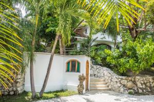 萨玛拉Villa Bruga en Samara Rocks的一座棕榈树掩映的白色房子