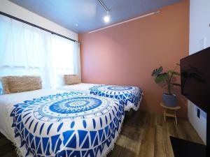 东京Luana Shibuya的一间卧室配有一张带蓝色和白色棉被的床