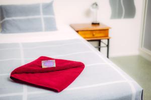 因尼斯费尔热带旅舍的白色床上的红色毛巾