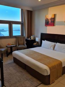 科威特Costa Del Sol Hotel by Arabian Link的酒店客房带一张大床和一把椅子