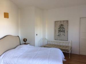 卢瓦尔河畔圣西CoTTAGE LA VILLA BOLERO的白色卧室配有床和沙发