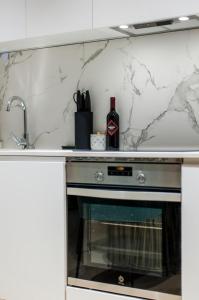 马德里Hauzify I Apartamento Salamanca的厨房配有带1瓶葡萄酒的炉灶