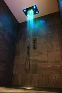 欧塞尔Spa privatif by XELA的设有带蓝色灯光淋浴的浴室