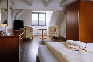 唐格明德SCHULZENS Brauerei & Hotel的一间卧室配有一张床、一张书桌和一台电视。