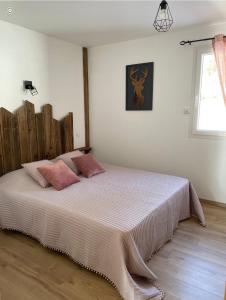 拉布雷斯Le cocon d’Emma的卧室配有一张带粉红色枕头的大床