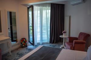 北马马亚-讷沃达里Hotel DNH的客房设有床、椅子和窗户。