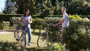 卡瓦利诺Appartamenti Giardino al Mare的公园里有自行车的男人和女人