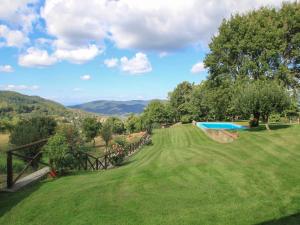 基安蒂的卢科莱纳Holiday Home Torsoli by Interhome的绿色庭院,设有游泳池和山脉
