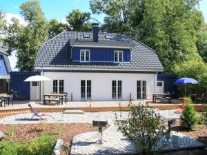 乌曼茨Holiday Home Boddenruhe by Interhome的蓝色和白色的房屋,设有庭院