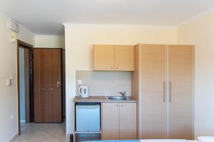 阿特米达Fotis Apartments的一个带木制橱柜和水槽的小厨房