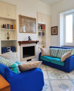 圣安吉洛Villa Falconieri Sorrento Suite的客厅配有2张蓝色沙发和壁炉