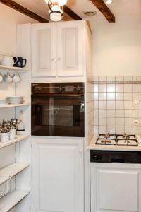 吕讷Holiday Home Le Coteau Fleury by Interhome的厨房配有白色橱柜和炉灶烤箱。