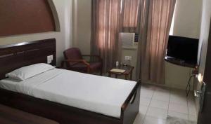 巴夫那加尔Wonderful View Hotel WR Bhavnagar的酒店客房,配有床和电视