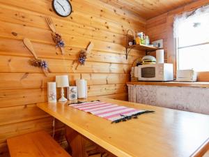 鲁卡卡尔帕托度假屋的厨房配有木墙、桌子和时钟