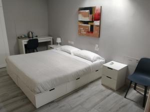 格拉索比奥BGY Airport House Grassobbio的卧室配有白色的床、书桌和椅子