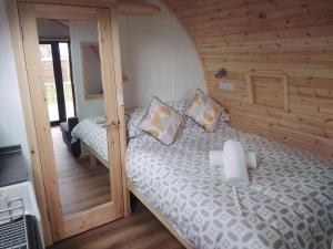 克罗默Glamping Pods的一间卧室配有一张木墙床