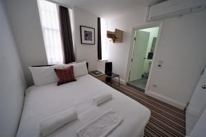巴尔金TBH Hotel的一张大白色的床,位于带镜子的房间里