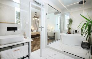 斯普利特Garden Luxury Room的白色的浴室设有浴缸和水槽。