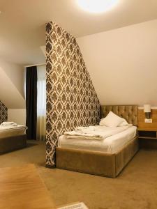 贝尤什Vila Turistica Principesa Margareta的一间卧室设有两张床,墙上设有床头板