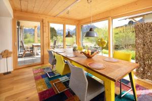 奥伯斯特多夫"Landhaus Panorama" - Luxuriöse Ferienwohnungen in bester Lage für gehobene Ansprüche的一间带木桌和椅子的用餐室