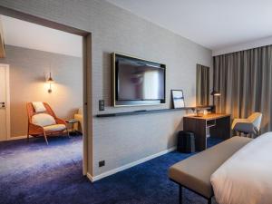 尼斯Crowne Plaza - Nice - Grand Arenas, an IHG Hotel的配有一张床和一台平面电视的酒店客房