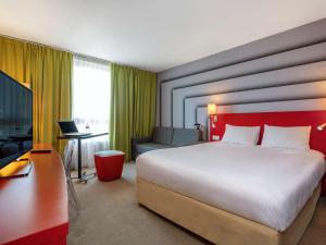 阿维尼翁南阿维农宜必思尚品酒店的酒店客房设有一张大床和一张书桌。