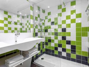 阿维尼翁南阿维农宜必思尚品酒店的浴室铺有绿色和白色瓷砖,配有水槽