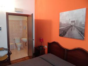米兰阿曼多拉菲耶拉酒店的一间卧室设有橙色墙壁、一张床和一间浴室