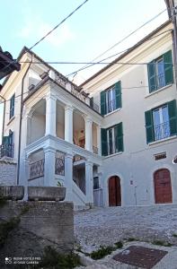 罗卡迪梅佐B&B Il Cardinale的白色的大房子,设有绿色百叶窗