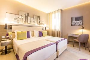 罗马奥拉齐奥皇宫酒店的酒店客房配有两张床和一张书桌