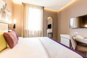 罗马奥拉齐奥皇宫酒店的酒店客房设有一张大床和一张书桌。