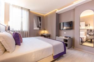 罗马奥拉齐奥皇宫酒店的配有一张大床和镜子的酒店客房