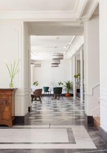 San Esteban de PraviaGran hotel Brillante的大楼内带桌椅的走廊