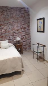 鲁伊德拉厄尔里欧乡村度假屋的一间卧室设有一张床和砖墙