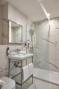布鲁塞尔The Scott Hotel Brussels的白色的浴室设有水槽和淋浴。
