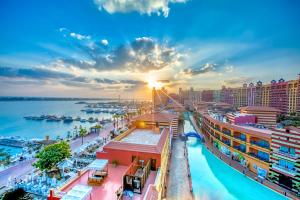 阿莱曼Porto Marina Resort & Spa Al Alamein的日落时分海港的城市景观