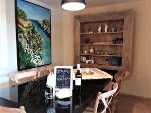 马纳科尔Apartment En Capillo的用餐室配有带1瓶葡萄酒的桌子