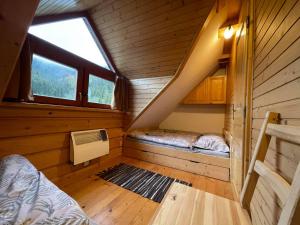 维许纳波察Apartmány SKI Čertovica的小屋内带两张床的小房间